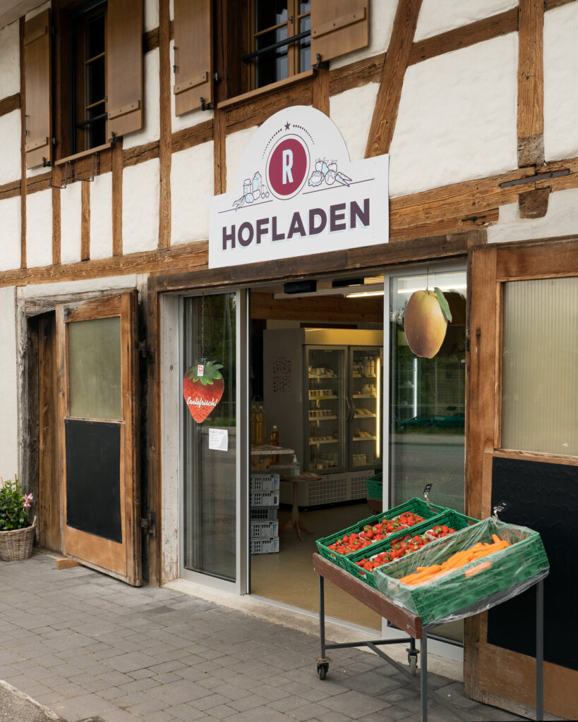 Eingang zum Hofladen auf dem Rüschenhof mit Erdbeeren und Karotten vor der Türe.